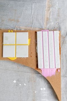 some white and yellow squares are sitting on a piece of cardboard