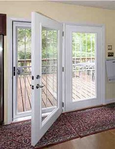 an open door leading into a kitchen with wooden floors and white doors on both sides