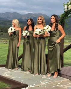 the bridesmaids are all dressed in olive green dresses with white flowers on their bouquets