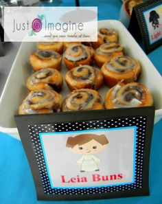 there is a tray full of donuts on the table with name tags in front of them