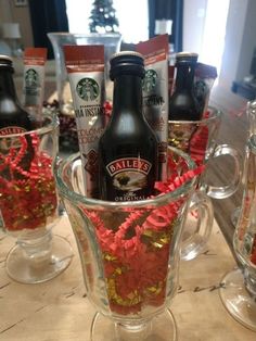 there is a glass cup with flowers in it and two bottles next to it on the table