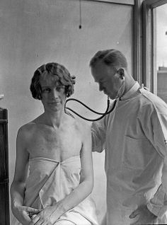 an old photo of a woman getting her blood checked by a doctor in the hospital