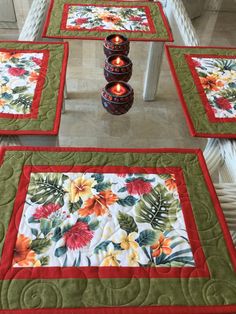 four quilted placemats with candles on them sitting on the floor next to each other