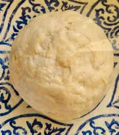 a ball of dough sitting on top of a blue and white plate