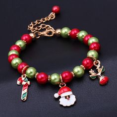 the bracelet is decorated with beads and santa clause charms, along with an ornament charm