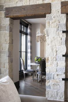 a living room filled with furniture and a fire place in front of a window next to a table