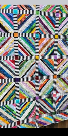 a multicolored quilt hanging on the wall