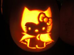 a pumpkin carved to look like a cat and kitten head with glowing eyes on it