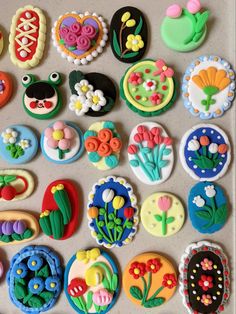 there are many decorated cookies on the table together, including flowers and plants in different shapes