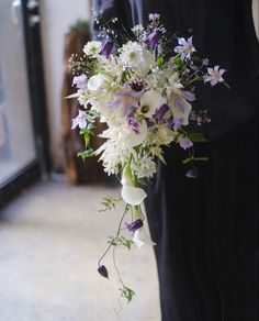 a man holding a bouquet of white and purple flowers