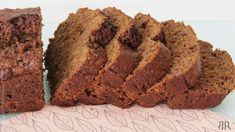 two slices of chocolate cake sitting next to each other on a pink napkin with leaves