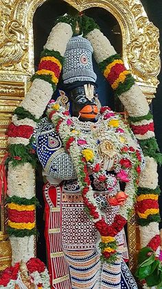 the statue is decorated with flowers and garlands