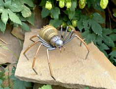 a large metal spider sitting on top of a rock