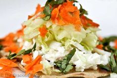 a white plate topped with lots of veggies and sauce on top of tortilla