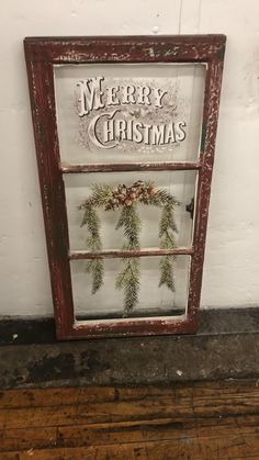 an old window decorated with christmas greenery and the words merry christmas written on it