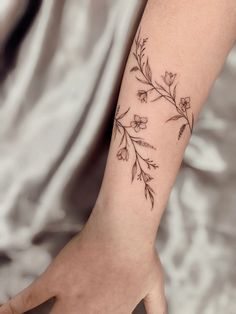 a woman's arm with a flower tattoo on it