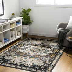 a living room area with a rug, chair and bookshelf on the floor