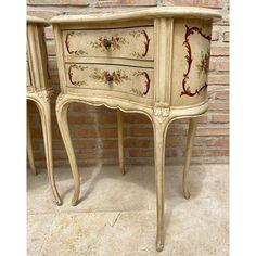 an old dresser with floral designs painted on it's sides and drawers is shown in front of a brick wall