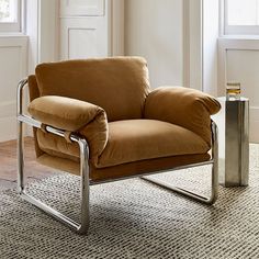 a brown chair sitting on top of a rug next to a metal table and window