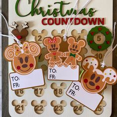 some christmas themed tags are hanging on a board with numbers and characters attached to them