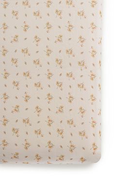 a white and yellow floral print sheet with small flowers on the bottom half of it