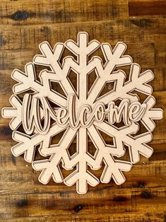 a wooden snowflake with the word welcome on it