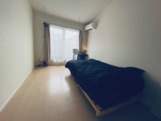 a bed sitting in the middle of a room next to a window