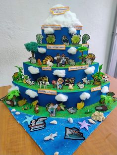 a blue cake with animals and clouds on it's tiered layer that says, i love you