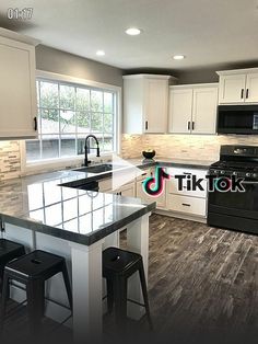 a kitchen with white cabinets and an island in the middle of it is featured on tiktok com