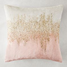 a pink and gold pillow on a white wall