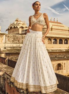 Our White Embroidered Brocade Lehenga includes a brocade top, brocade with crepe inner bottom, and a net dupatta. Embroidery is present on this style using thread, zari, stone, and hand work. Like all of our pieces, this piece is made in India and checked by hand to ensure high quality. Wedding Brocade Palazzo Set With Zari Work, Festive Brocade Sharara For Reception, Festive Brocade Palazzo Set For Wedding, Anarkali Brocade Choli With Gota Work, Brocade Sets With Gota Work For Reception, Anarkali Style Brocade Choli With Gota Work, Reception Brocade Sets With Gota Work, Semi-stitched Brocade Lehenga With Gota Work, Semi-stitched Brocade Anarkali Set With Gota Work