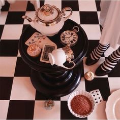 a black and white checkered floor with tea set on it