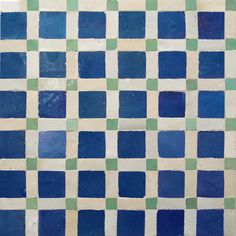 a blue and green tiled wall with squares