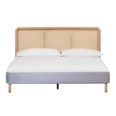 the headboard and foot board of a bed with white sheets, pillows and linens