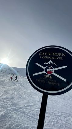 a sign on the side of a snow covered ski slope