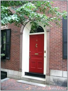 a red door is on the side of a brick building