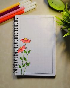 a notebook with flowers drawn on it next to some markers