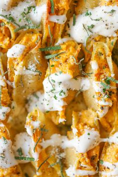 a close up view of some pasta with cheese and herbs on top, in a pan