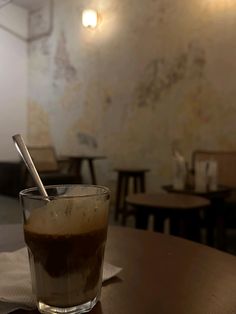 a glass filled with liquid sitting on top of a wooden table