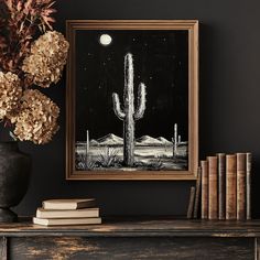 a black and white painting on a wall next to books