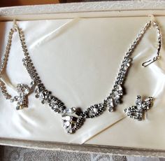 "Vintage rhinestone set with a wide array of shaped stones.   The necklace is 15\" long and the center is a little over 1\"tall.  Earrings are about 1 1/4\" long and 1/2\" tall.  The earrings are kind of like ear huggers, depending on how you put them on.  All the rhiniestones are present and still sparkly.  One of the small rhinestones on an earring has a greenish cast which is probably some corrosion on the interior.  Only one exterior spot of corrosion on the back.  The original box has usual Vintage Rhinestone Necklace, Rhinestone Necklace, Vintage Rhinestone, Original Box, Clip On Earrings, Jewelry Sets, Anniversary Gifts, Beauty Book, Accessory Gift