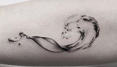 a black and white photo of a wave tattoo on the arm