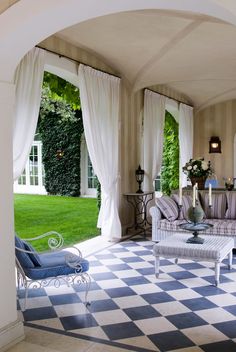 a living room filled with lots of furniture next to a lush green field in the background