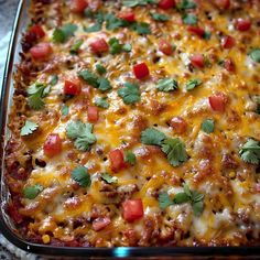 a casserole dish with cheese, tomatoes and cilantro