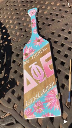 a wooden paddle sitting on top of a metal grate next to paintbrushes