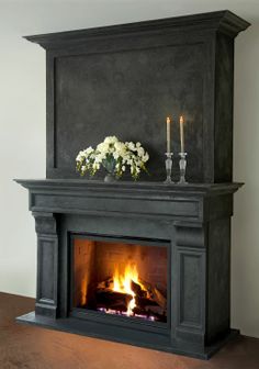 a fireplace with candles and flowers on it