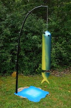 a large blue and yellow object sitting on top of a lush green field