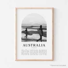 a black and white photo of two surfers carrying their surfboards on the beach