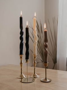 three candles sitting on top of a wooden table