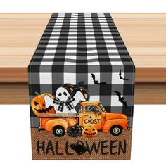 an orange truck decorated with black and white checkered tablecloths is sitting in front of a wooden surface